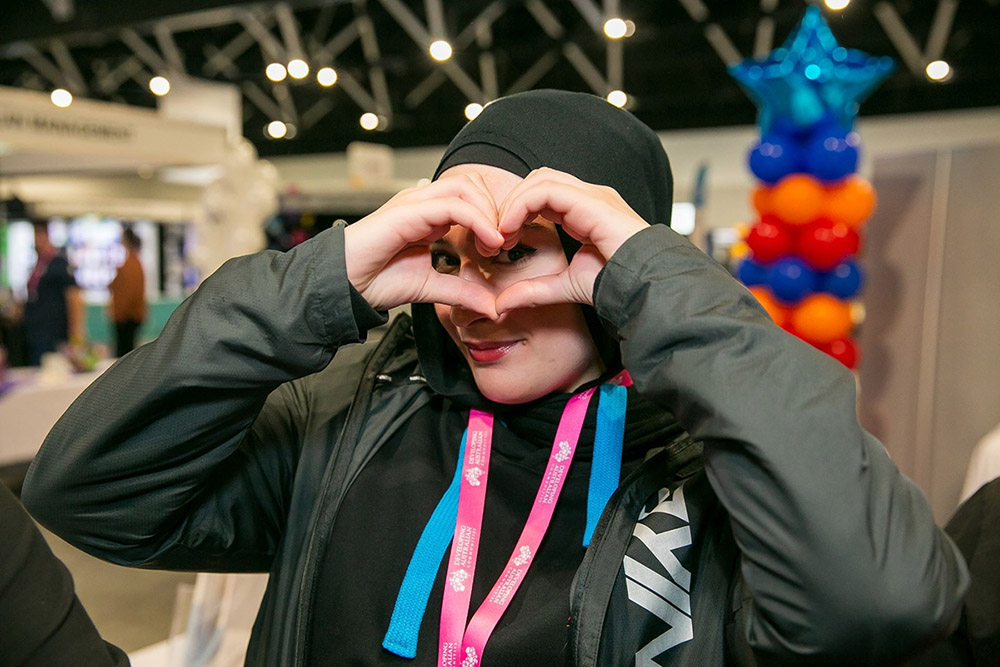 Woman from the organization is making a heart shape with her hands