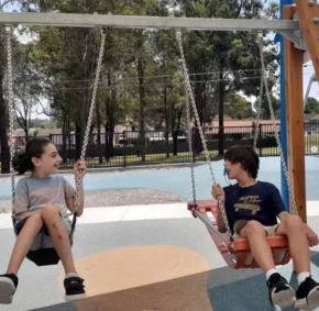 two friends are swinging and playing together